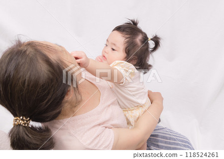 Baby touching grandma's face 118524261