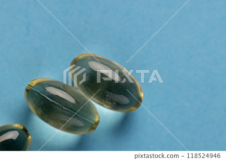 transparent fish oil capsules on blue paper transparent fish oil capsules on blue paper 118524946