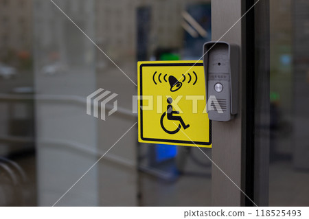 Button to call staff to assist person with disabilities at entrance. Accessible environment for people in wheelchair, entrance to modern building with conditions for the disabled people Button to call staff to assist person with disabilities at entrance. Accessible environment for people in wheelchair, entrance to modern building with conditions for the disabled people 118525493