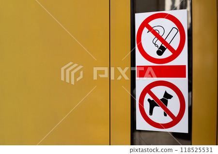 Signs prohibiting smoking and entry into building with dogs. Restricted area with no access for pets. Crossed out cigarette and dog on sticker on building door 118525531