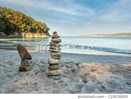 Pyramid stones balance on the sand of the beach. The object is in focus, the background is blurred Pyramid stones balance on the sand of the beach. The object is in focus, the background is blurred 118526893