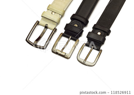 Three leather belts of different sizes lie on a white background 118526911