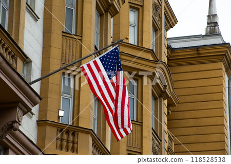 Striped American flag with symbols of all states in form of stars flies in flagpole on building, symbol of the American Dream and freedom 118528538