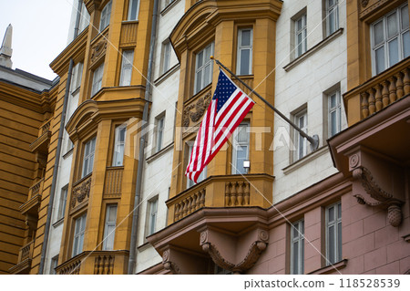 Attribute of American freedom, national flag of United States of America flies against background of building, symbol of America in flagpole on building 118528539