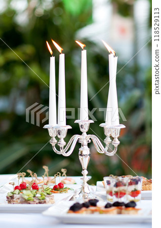 Catering buffet table with snacks and appetizers and candles 118529113