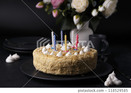 Whole holiday cake with crumbly shortcrust pastry and mini meringue. Birthday cake with extinguished candles. Homemade baking. Black background, selective focus, close-up. 118529585