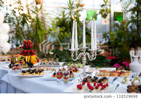Catering buffet table with snacks and appetizers and candles Catering buffet table with snacks and appetizers and candles 118529698