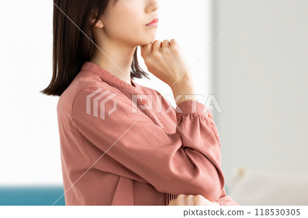 A young woman thinking in the living room 118530305