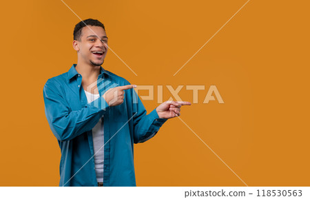Stylish smiling multiracial man pointing right side, copy space or advertising. 118530563