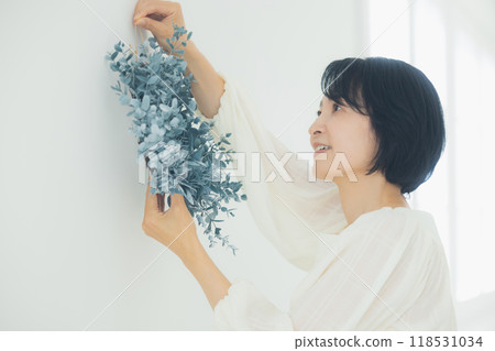 Middle-aged woman holding a wreath Middle-aged woman holding a wreath 118531034