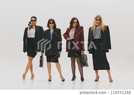 Stylish women, each in powerful stance with business attire, sunglasses, and briefcases against white studio background. Professionalism. Stylish women, each in powerful stance with business attire, sunglasses, and briefcases against white studio background. Professionalism. 118531188
