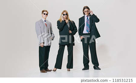 Three confident professionals stand tall in oversized suits and sharp ties, combining classic business style with bold, modern edge. Three confident professionals stand tall in oversized suits and sharp ties, combining classic business style with bold, modern edge. 118531215