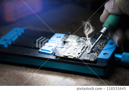 Side view of mechanic doing repairs Smartphone motherboard, smartphone repair, circuit repair 118531645