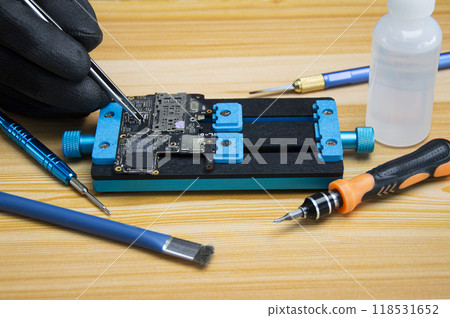 Technician is repairing Smartphone motherboard, circuit repair Technician is repairing Smartphone motherboard, circuit repair 118531652