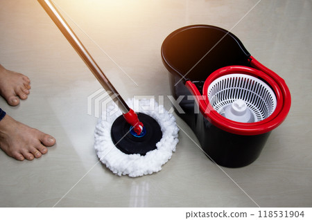 The housekeeper is mopping the floor and cleaning. 118531904