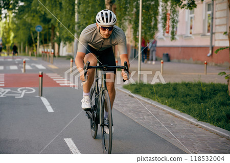 Man bicyclist riding fast to place of destination using city bicycle path Man bicyclist riding fast to place of destination using city bicycle path 118532004