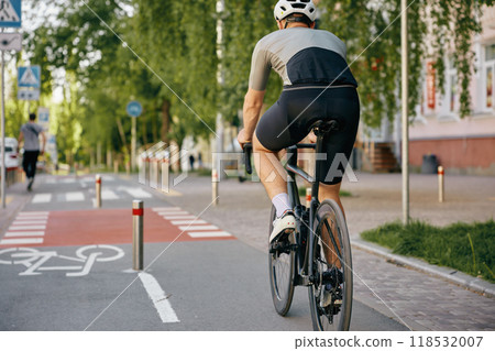 Back view of man bicyclist riding fast to place of destination using city bicycle path 118532007
