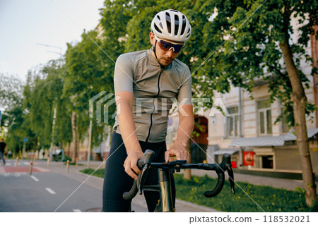 Bicyclist stopped on sidewalk to check speed parameters on bicycle speedometer Bicyclist stopped on sidewalk to check speed parameters on bicycle speedometer 118532021