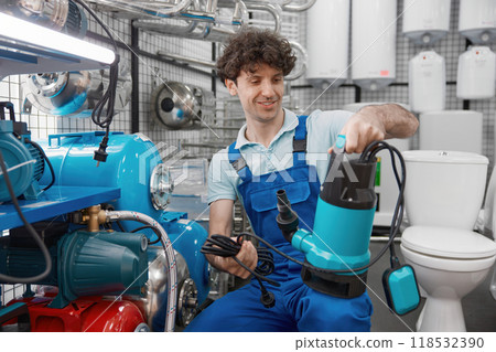 Plumber choosing water pump for heating systems at plumbing store 118532390