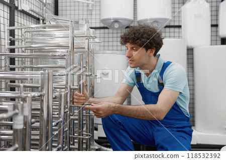 Plumber choosing metallic heated towel rail at plumbing store department 118532392
