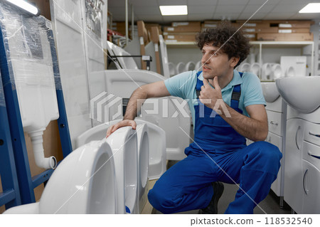 Plumber choosing new ceramic lavatory bowl at plumbing shop 118532540