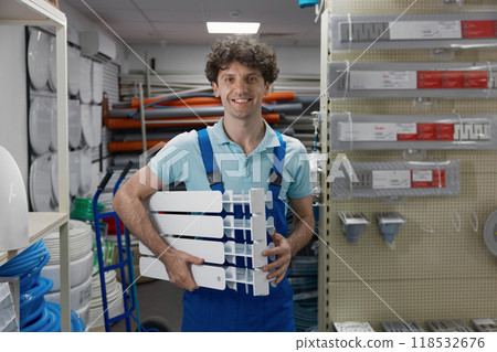 Portrait of happy smiling satisfied plumber holding section of radiator 118532676