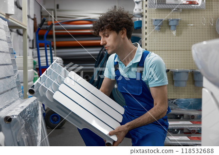 Portrait of plumber holding section of radiator Portrait of plumber holding section of radiator 118532688