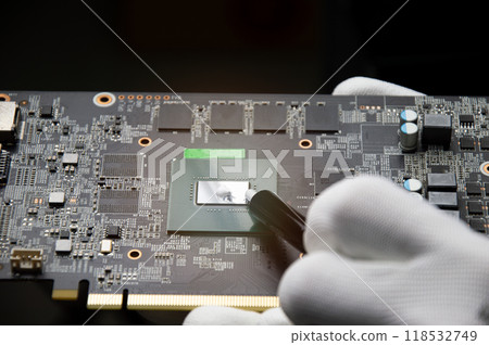 The technician is adding cooling silicone. Graphics motherboards and graphics card repairs, computer parts 118532749