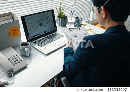 Businesswoman Examining Financial Graphics At Her Workplace 118533007