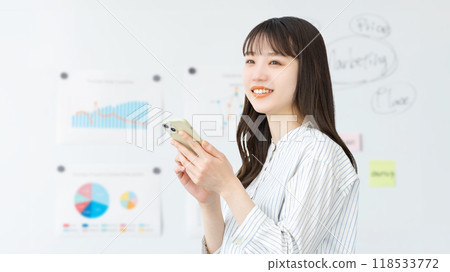 Smiling business woman holding a smartphone 118533772