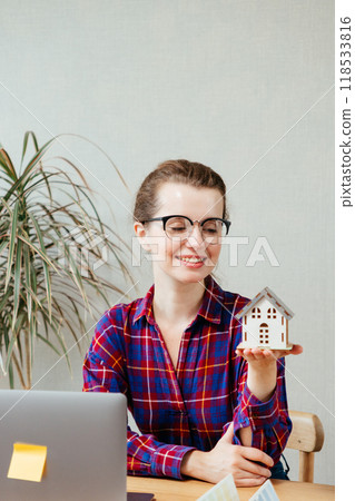 female architect is holding mock-up house, scale model building, thinking sketch for design courses.  118533816