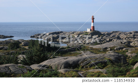Cast iron Eigeroy lighthouse, rock formations and sea, Norway. 118534910