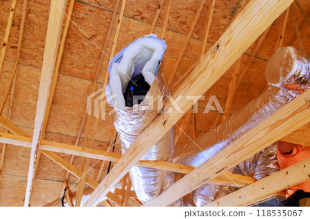 In construction of home, silver insulation ventilation HVAC pipes were installed from ceiling to roof In construction of home, silver insulation ventilation HVAC pipes were installed from ceiling to roof 118535067