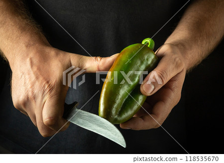 Cutting bell pepper with knife in chef hands. Concept on black background of cooking vegetable dish. Cutting green pepper Cutting bell pepper with knife in chef hands. Concept on black background of cooking vegetable dish. Cutting green pepper 118535670