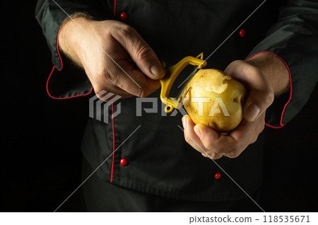 Chef peeling raw potatoes. Concept of cooking potatoes for chips or French fries. Potato diet menu 118535671