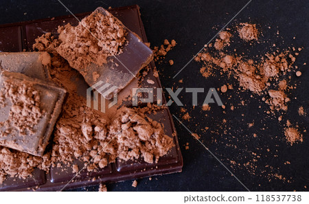 Black chococlate chips and cocoa powder on dark background. Black chococlate chips and cocoa powder on dark background. 118537738