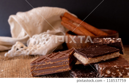 Decorative stack of different flavoured chocolates in a rustic kitchen. Decorative stack of different flavoured chocolates in a rustic kitchen. 118537759