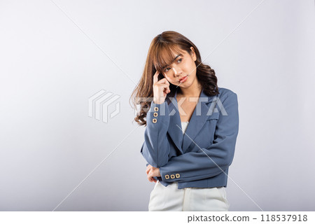 Portrait of an Asian business woman deep in thought thinking chin in her finger, pondering a question. Studio shot on white background with ample copy space, portraying her contemplative expression Portrait of an Asian business woman deep in thought thinking chin in her finger, pondering a question. Studio shot on white background with ample copy space, portraying her contemplative expression 118537918