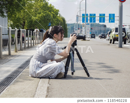 Female photographer taking pictures in the park 118540228