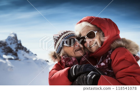 Couple of elderly women clad in ski gear share a heartwarming embrace at the snowy summit of a mountain 118541078