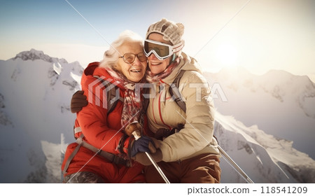 Couple of elderly women clad in ski gear share a heartwarming embrace at the snowy summit of a mountain 118541209