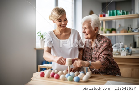A medical professional engages in therapeutic exercises with an elderly woman in a wheelchair, utilizing a ball and various aids, exemplifying compassionate care and rehabilitation support in the 118541637