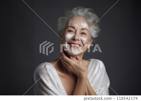 Elderly woman applies facial cream, gracefully embracing a skincare routine 118542174