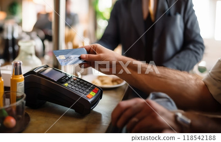A customer at a cafe or restaurant completes a seamless transaction, using a credit card to pay at the cashier, showcasing the convenience of digital payment in the dining experience.Generated image 118542188