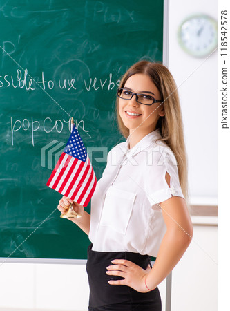 Young female english language teacher standing in front of the b 118542578