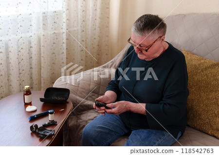 senior grandmother, her gray hair and glasses perched on her nose, intently focuses on the glucometer in her hands, a vital part of her daily diabetes care regimen senior grandmother, her gray hair and glasses perched on her nose, intently focuses on the glucometer in her hands, a vital part of her daily diabetes care regimen 118542763