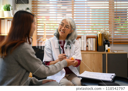 Experienced senior doctor having a discussion with a young female patient in medical office Experienced senior doctor having a discussion with a young female patient in medical office 118542797