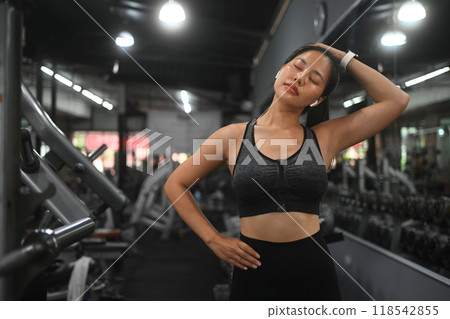 Beautiful young sports woman warming up during sports training in gym 118542855