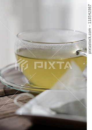 Hot green tea brewed in a triangular tea bag Hot green tea brewed in a triangular tea bag 118542867