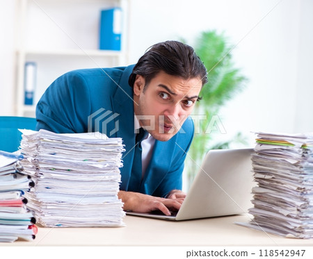 Young male employee unhappy with excessive work Young male employee unhappy with excessive work 118542947